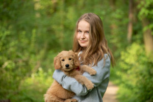 Girl on a forest walk with a dog, Mini Goldendoodle Girl on a forest walk with a dog, Mini Goldendoodle